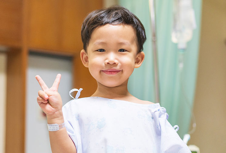 The patient boy is happy in the hospital, He has a cheerful grin.