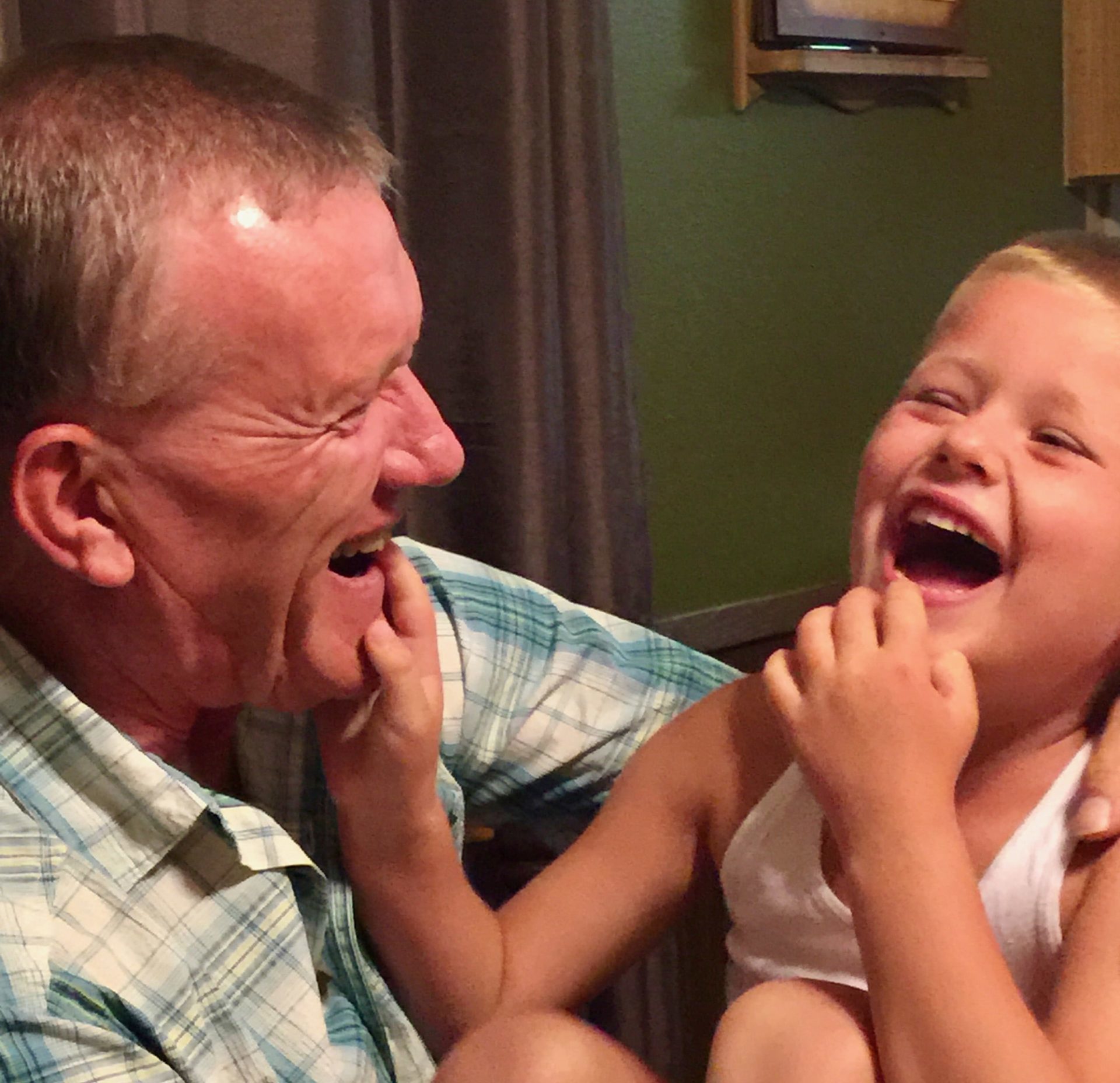  a grandpa and his grandson laughing.