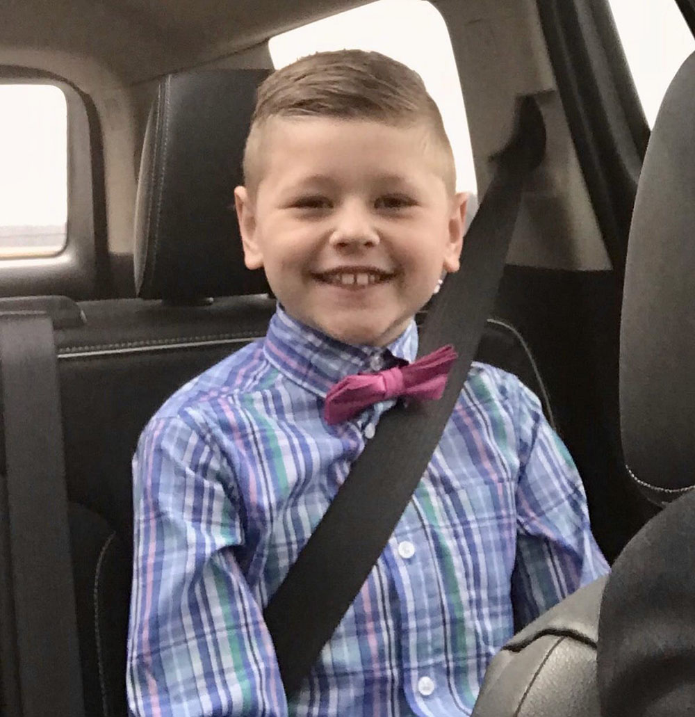 boy smiling buckled up in a car.